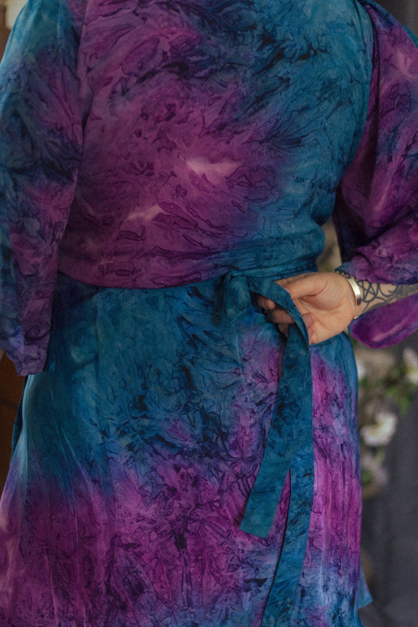 Person wearing a tie-dye outfit with purple and blue patterns.
