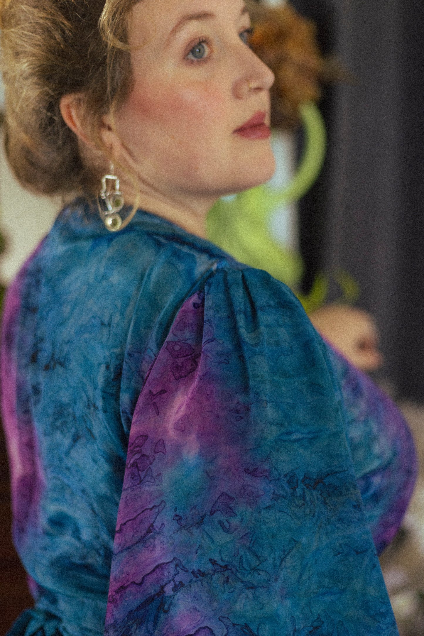 Woman wearing a blue and purple patterned dress with a blurred background