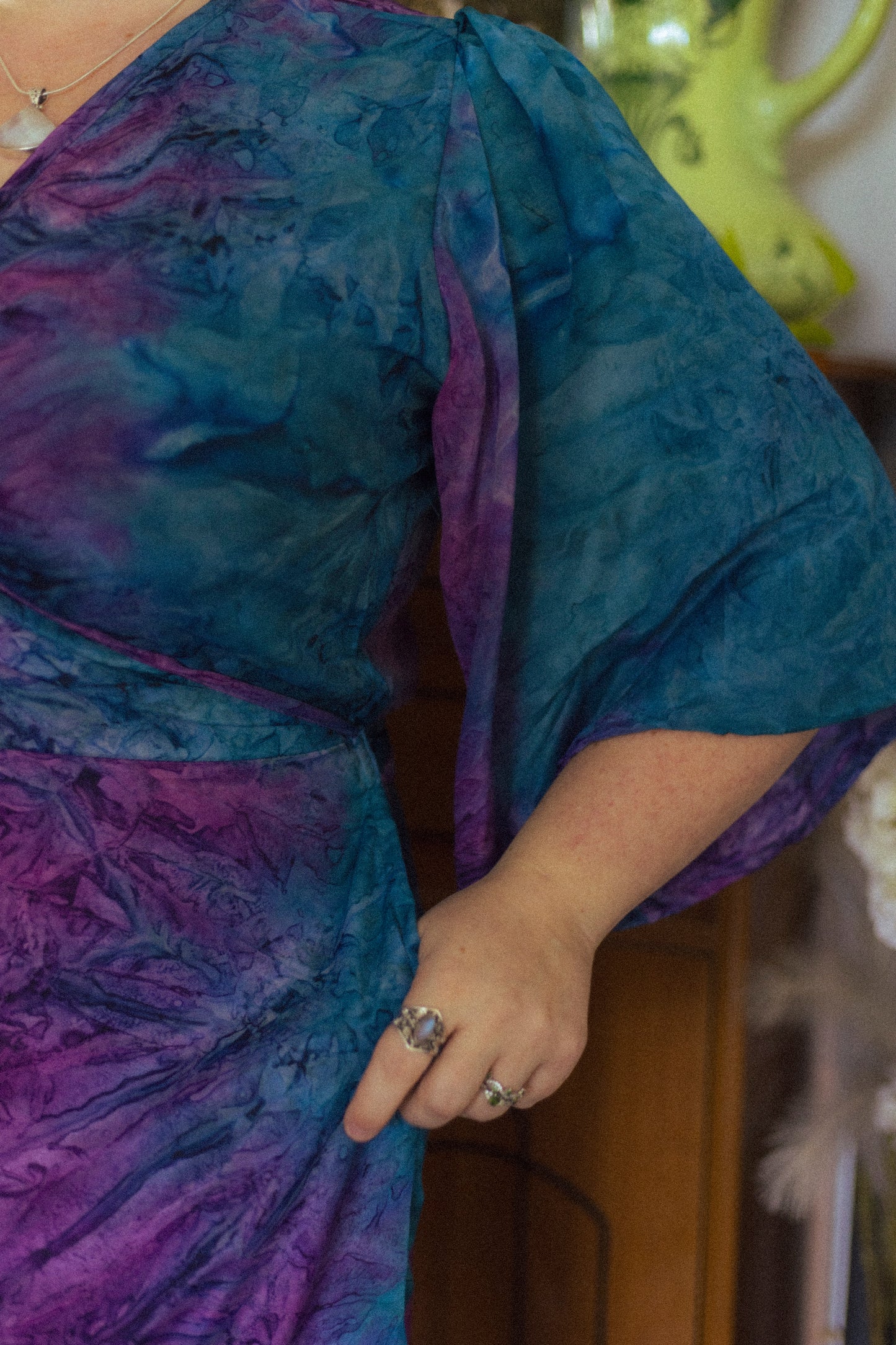 Person wearing a blue and purple tie-dye garment with a blurred background