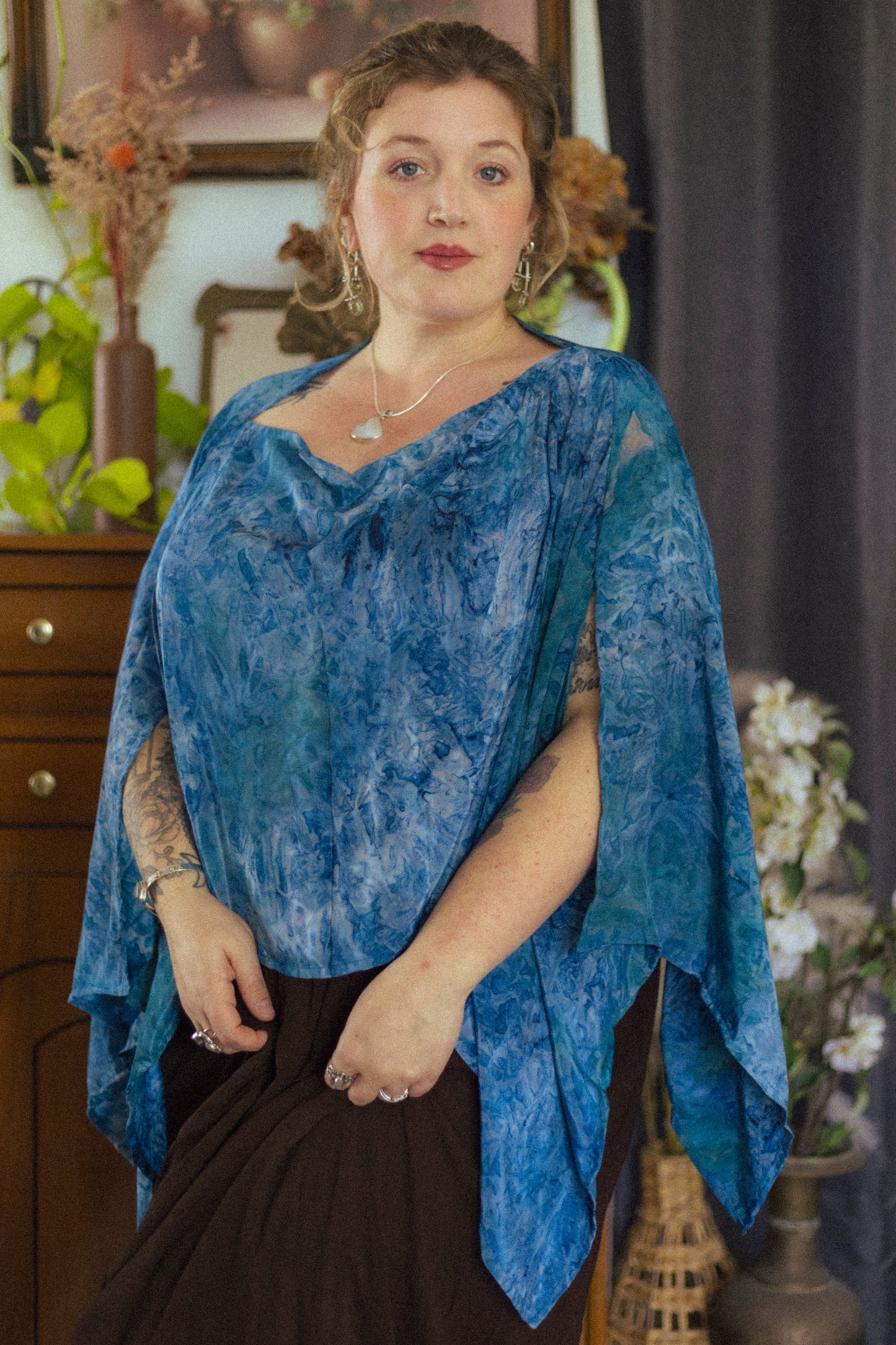 Woman wearing a blue patterned top with a dark background