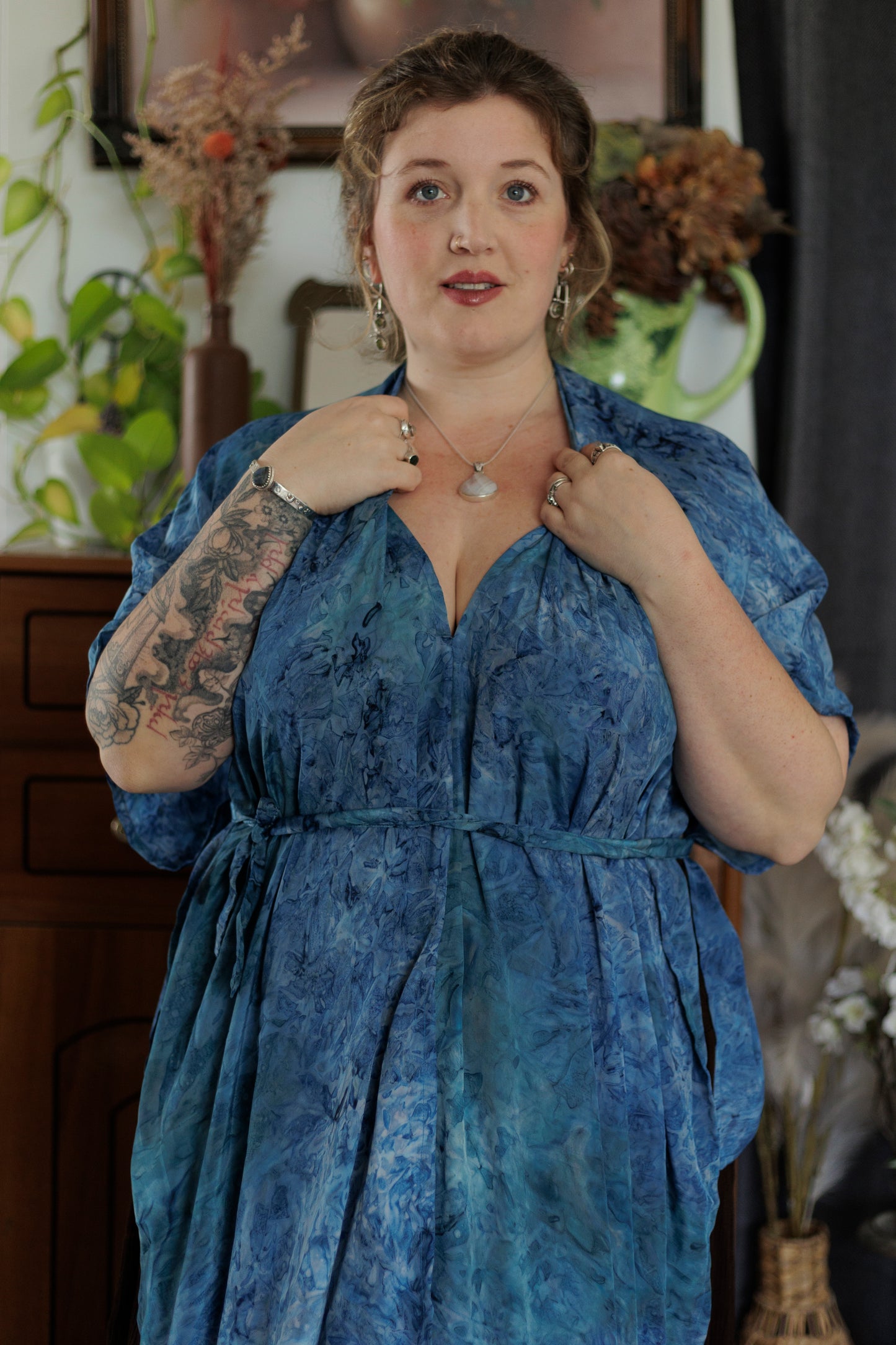 Woman wearing a blue dress with a blurred indoor background