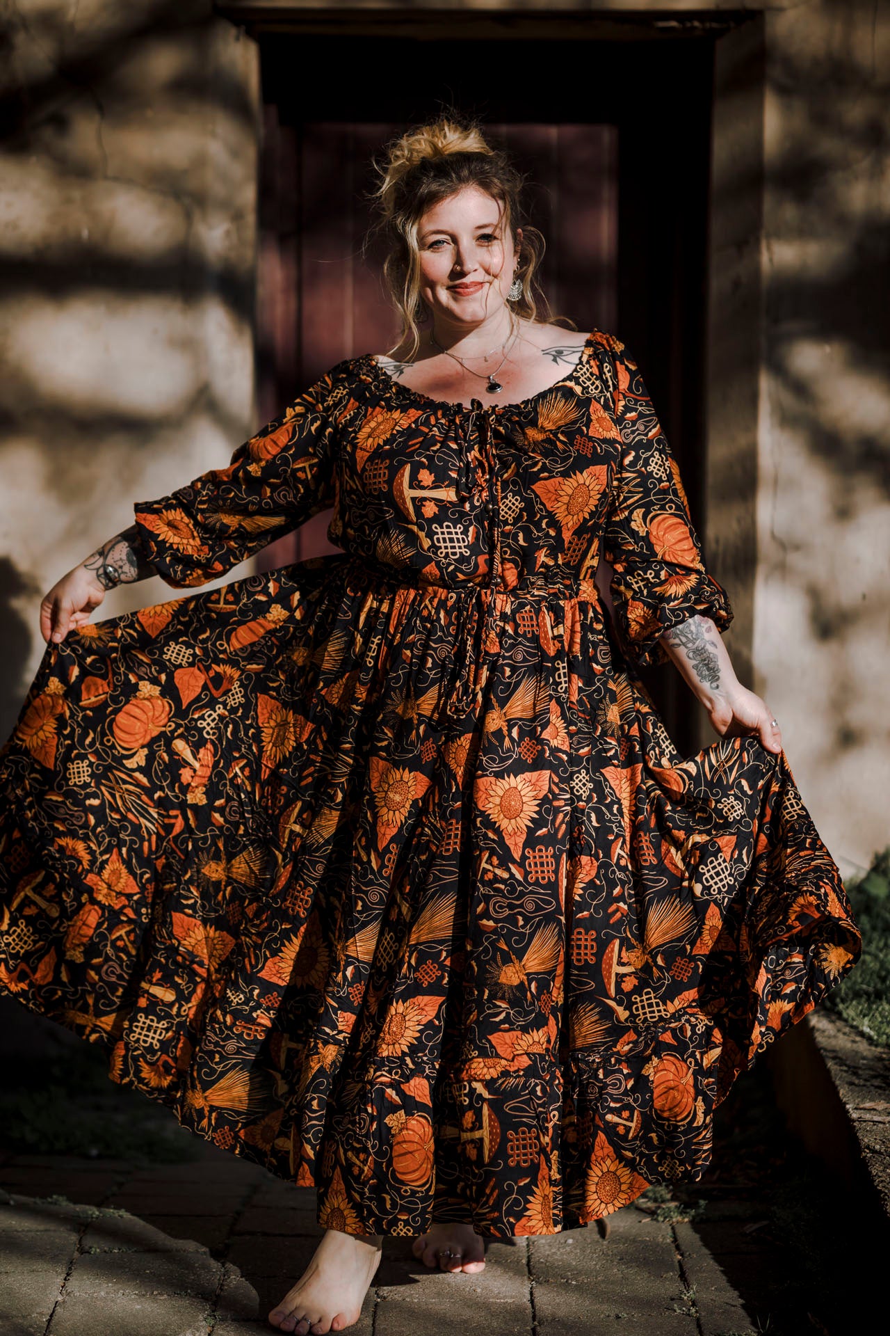 Woman wearing a long, patterned dress standing outdoors.
