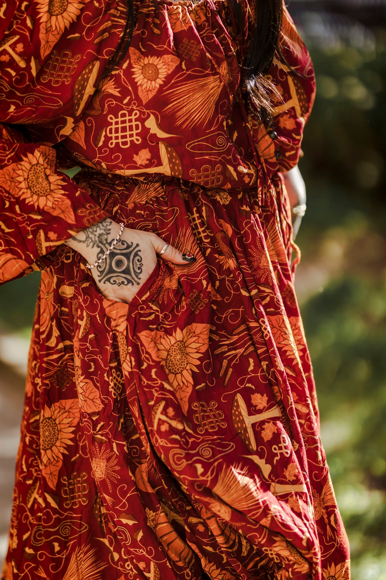 Person wearing a red patterned garment with a decorative belt buckle.