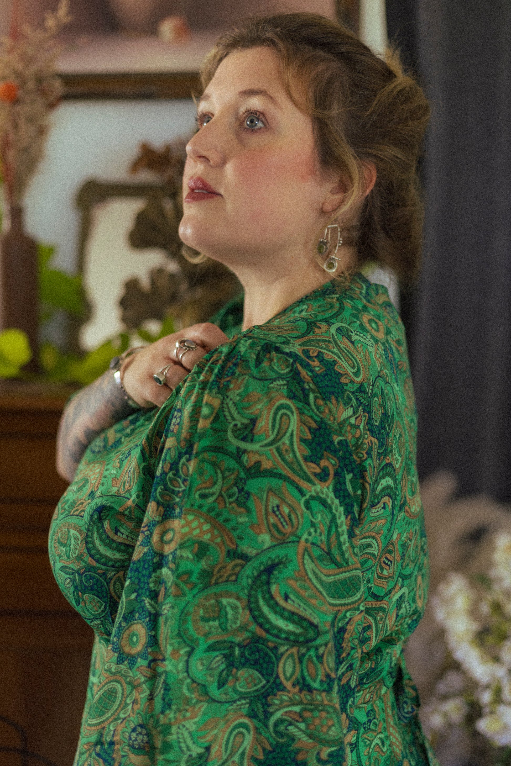 Woman wearing a green patterned outfit in an indoor setting