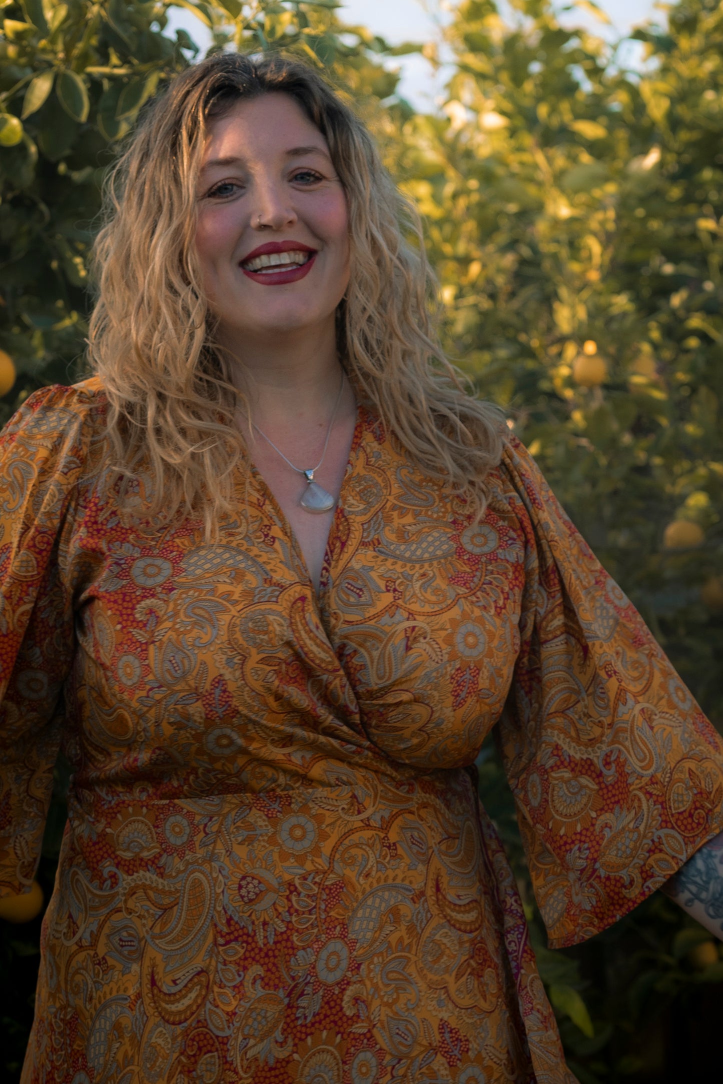 Woman wearing a patterned dress with a blurred natural background